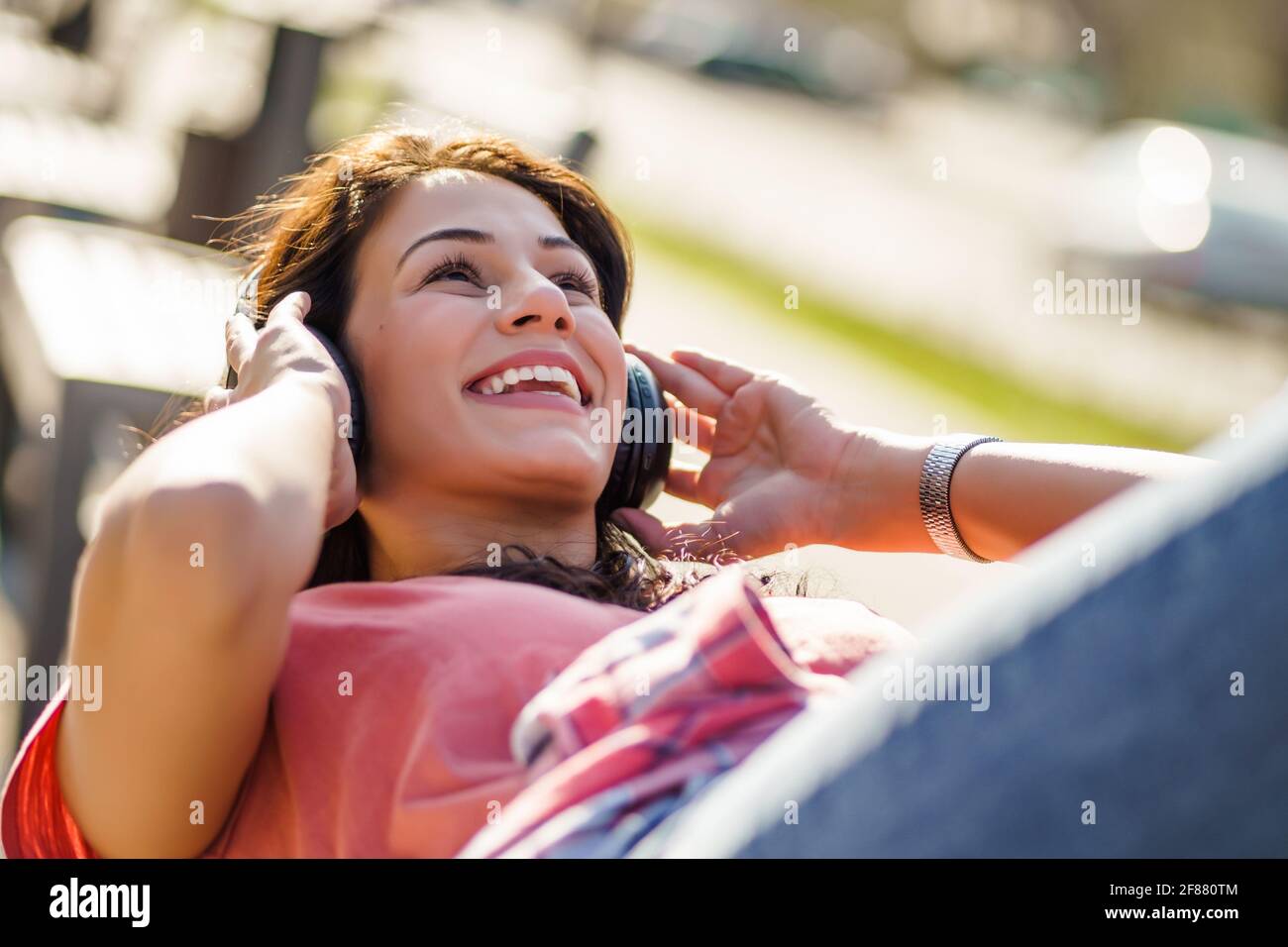 Felice giovane donna sta godendo di una giornata di sole all'aperto in città. Foto Stock