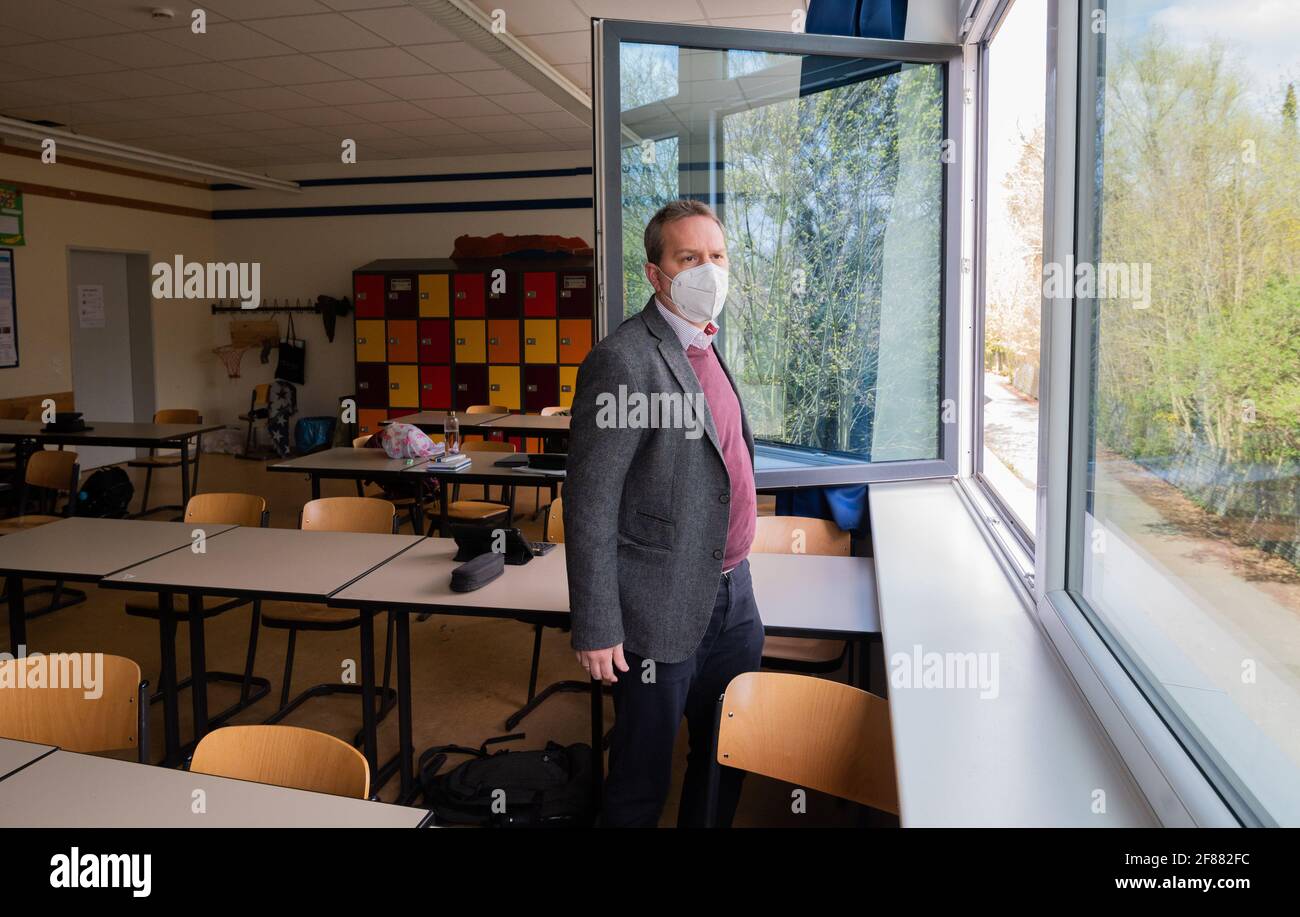 Hildesheim, Germania. 12 Aprile 2021. Rene Mounajed, amministratore delegato della Lower Saxony School Management Association e direttore della Robert Bosch Comprehensive School di Hildesheim, apre le finestre in una classe della sua scuola. L'inizio degli autotest obbligatori Corona per studenti e insegnanti è stato caotico dal punto di vista dell'Associazione di gestione delle scuole della bassa Sassonia. Credit: Julian Stratenschulte/dpa/Alamy Live News Foto Stock