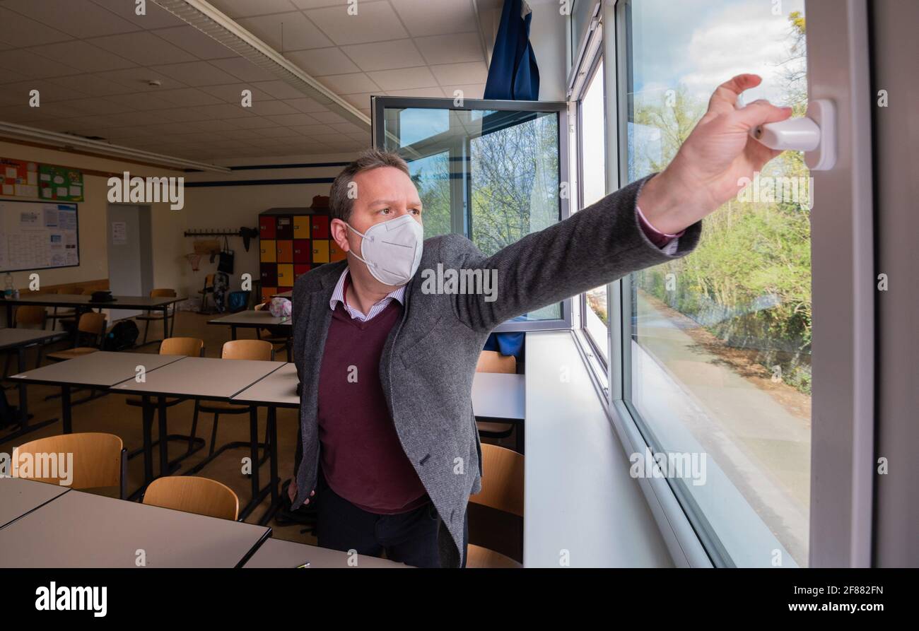 Hildesheim, Germania. 12 Aprile 2021. Rene Mounajed, amministratore delegato della Lower Saxony School Management Association e direttore della Robert Bosch Comprehensive School di Hildesheim, apre le finestre in una classe della sua scuola. L'inizio degli autotest obbligatori Corona per studenti e insegnanti è stato caotico dal punto di vista dell'Associazione di gestione delle scuole della bassa Sassonia. Credit: Julian Stratenschulte/dpa/Alamy Live News Foto Stock