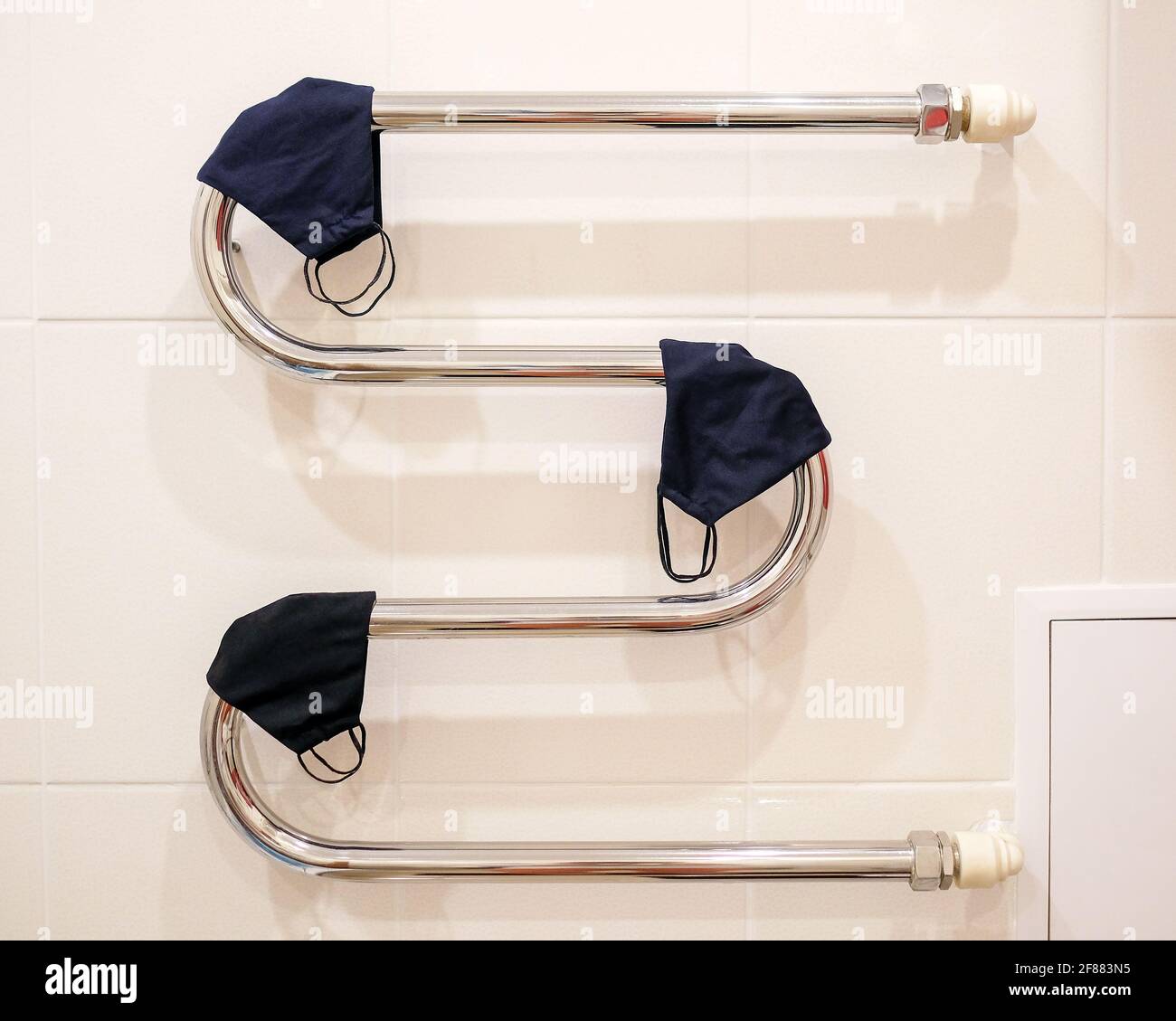 Molte maschere di tessuto sono asciugate su un radiatore. Maschere protettive per essiccazione. Foto Stock