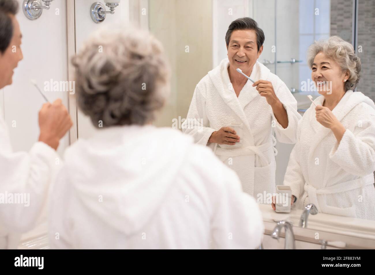 Felice coppia anziana spazzolando i denti in bagno Foto Stock