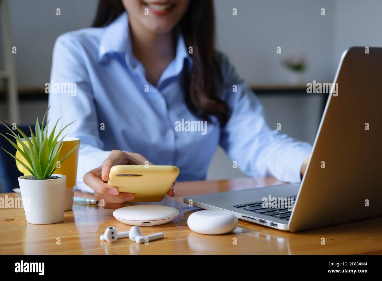 Donna che utilizza il concetto di tecnologia di ricarica wireless. Foto Stock