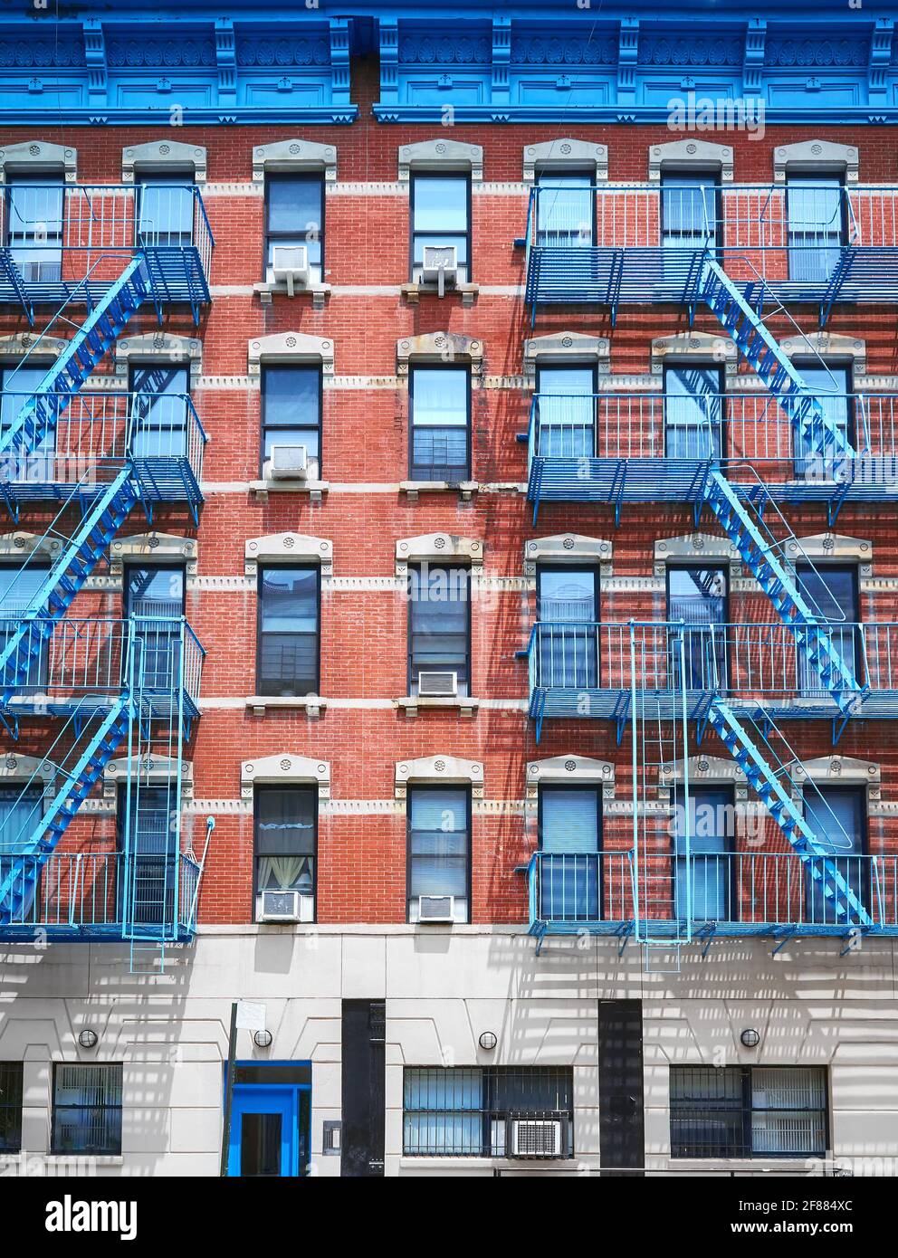 Vecchio edificio in mattoni rossi con scappate di ferro blu, New York City, USA. Foto Stock