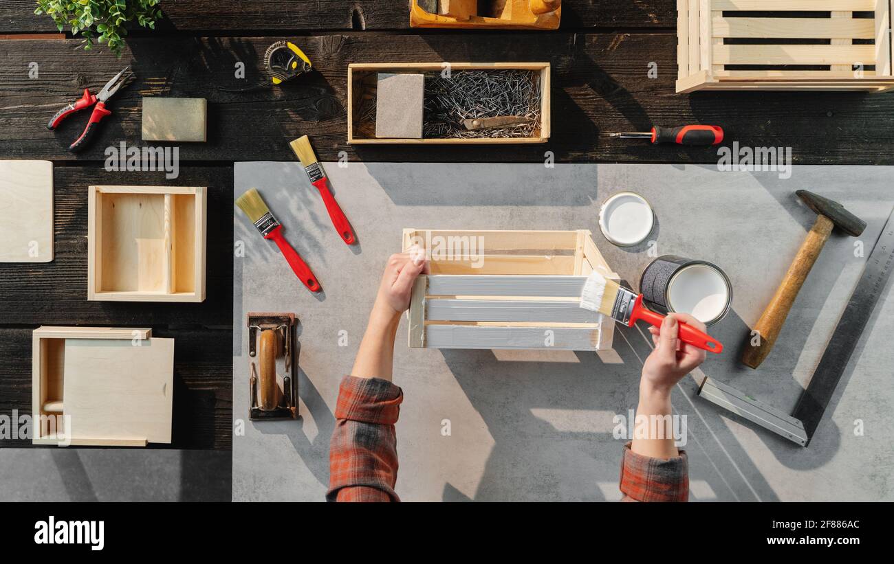 Vista dall'alto di una donna irriconoscibile che fa scatole di legno, piccole aziende e desktop concept. Foto Stock