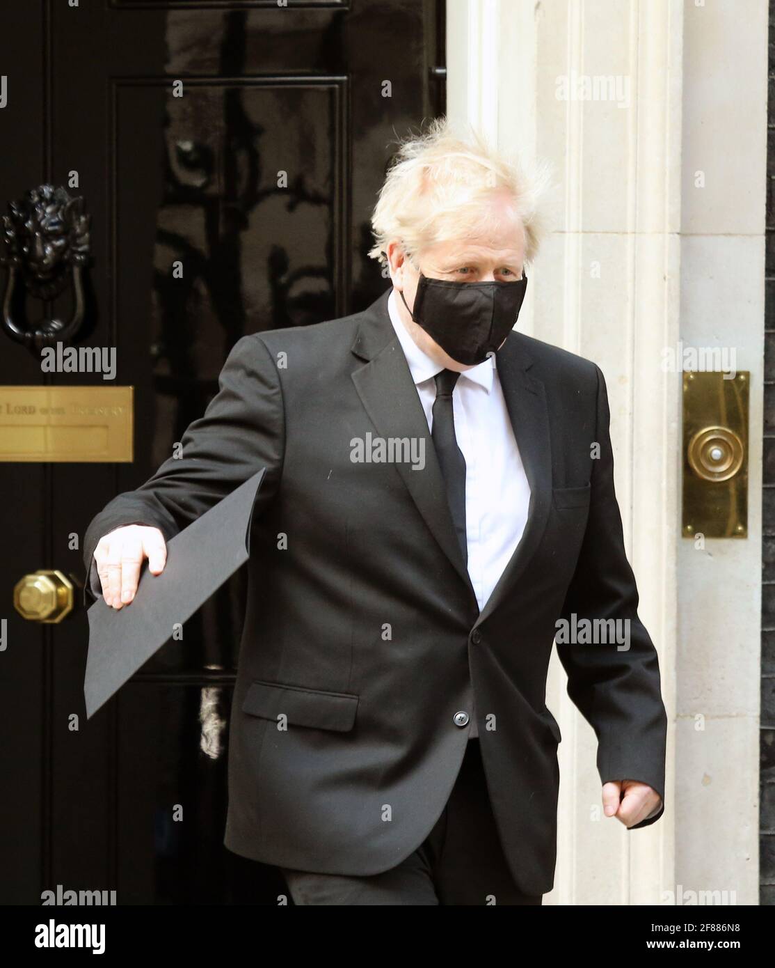 Londra, Inghilterra, Regno Unito. 12 Aprile 2021. Il primo ministro britannico BORIS JOHNSON con un taglio di capelli fresco e maschera nera e cravatta lascia 10 Downing Street prima della sessione in onore del principe Filippo nella Camera dei Comuni. Credit: Tayfun Salci/ZUMA Wire/Alamy Live News Foto Stock