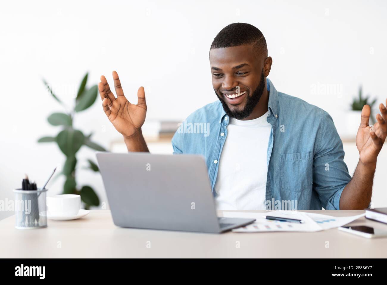 Happy Black Freelancer uomo celebrando il successo mentre lavorando on-line Computer Foto Stock