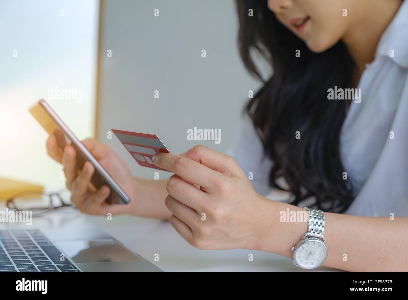 Shopping online. Donna asiatica che scrive le informazioni della carta di credito dal laptop per lo shopping in linea. Foto Stock