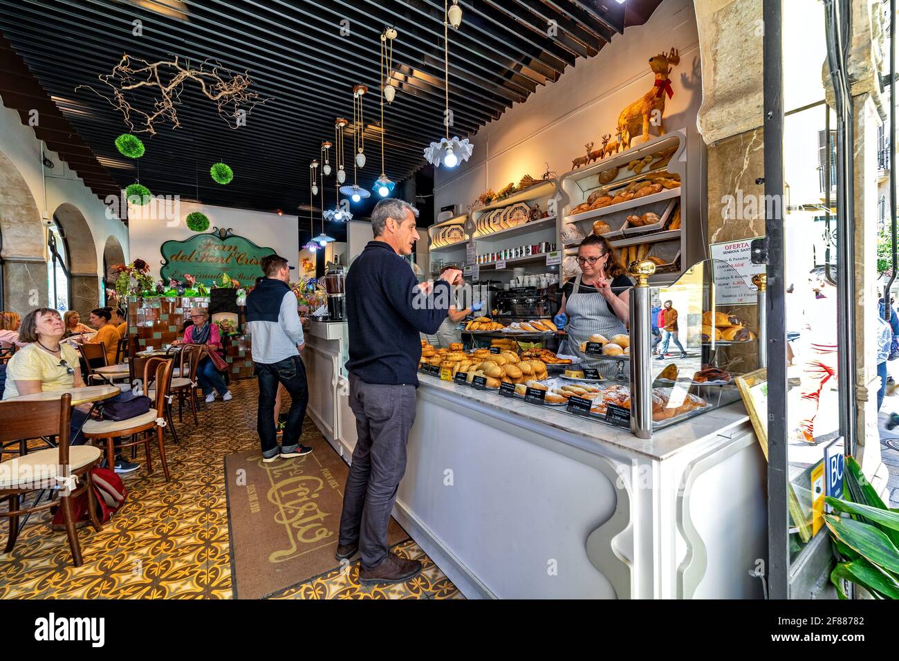 Persone all'interno del forno del Santo Cristo - famosa panetteria nel centro storico di Palma di Maiorca, Spagna. Foto Stock