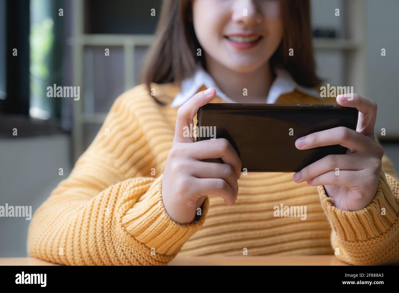 Giovane donna asiatica sorpresa da incredibili buone notizie, fantastica offerta di viaggi online guardando smartphone. Foto Stock