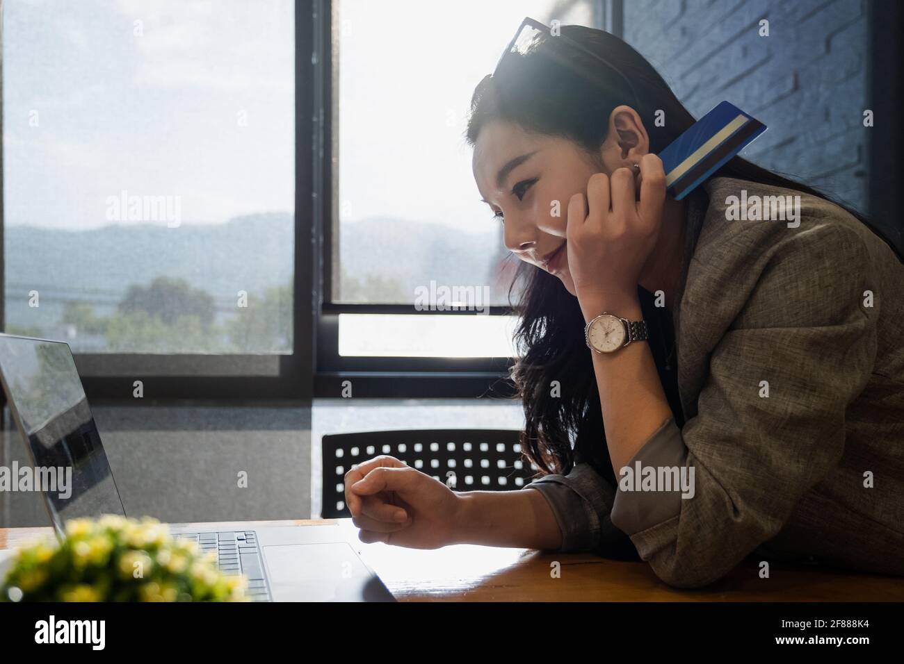 Shopping online. Donna asiatica che scrive le informazioni della carta di credito dal laptop per lo shopping in linea. Foto Stock