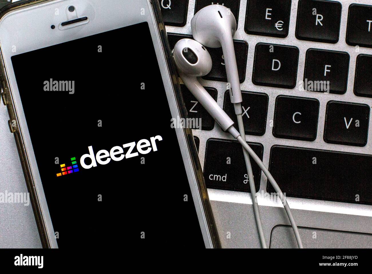 12 aprile 2021, Barcellona, Catalogna, Spagna: In questa illustrazione fotografica, un'app Deezer visualizzata su uno smartphone con cuffie sulla tastiera di un computer portatile. (Immagine di credito: © Thiago Prudencio/DAX via ZUMA Wire) Foto Stock