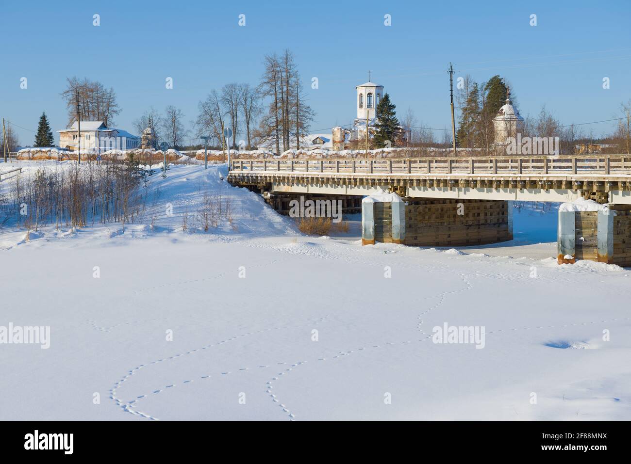 Vista dell'Assunzione del Monastero di Alexandro-Oshevensky dalla riva del fiume Churyega in un giorno di sole di febbraio. Regione di Arakhangelsk, Russia Foto Stock