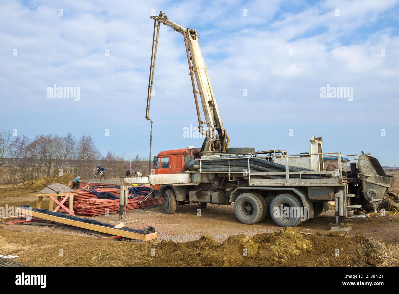 REGIONE DI LENINGRAD, RUSSIA - 28 MARZO 2021: Una pompa di calcestruzzo basata su un camion Kamaz sul cantiere di una casa di campagna in una giornata di sole primavera Foto Stock
