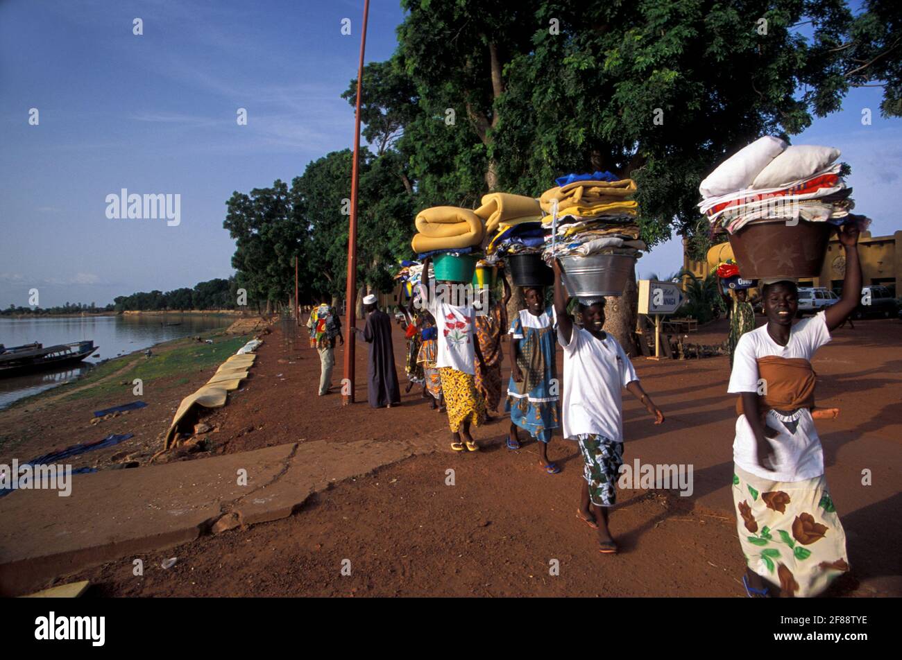 Donne che trasportano i panni puliti a Mopti, regione interna del Delta del Niger, Mali Foto Stock