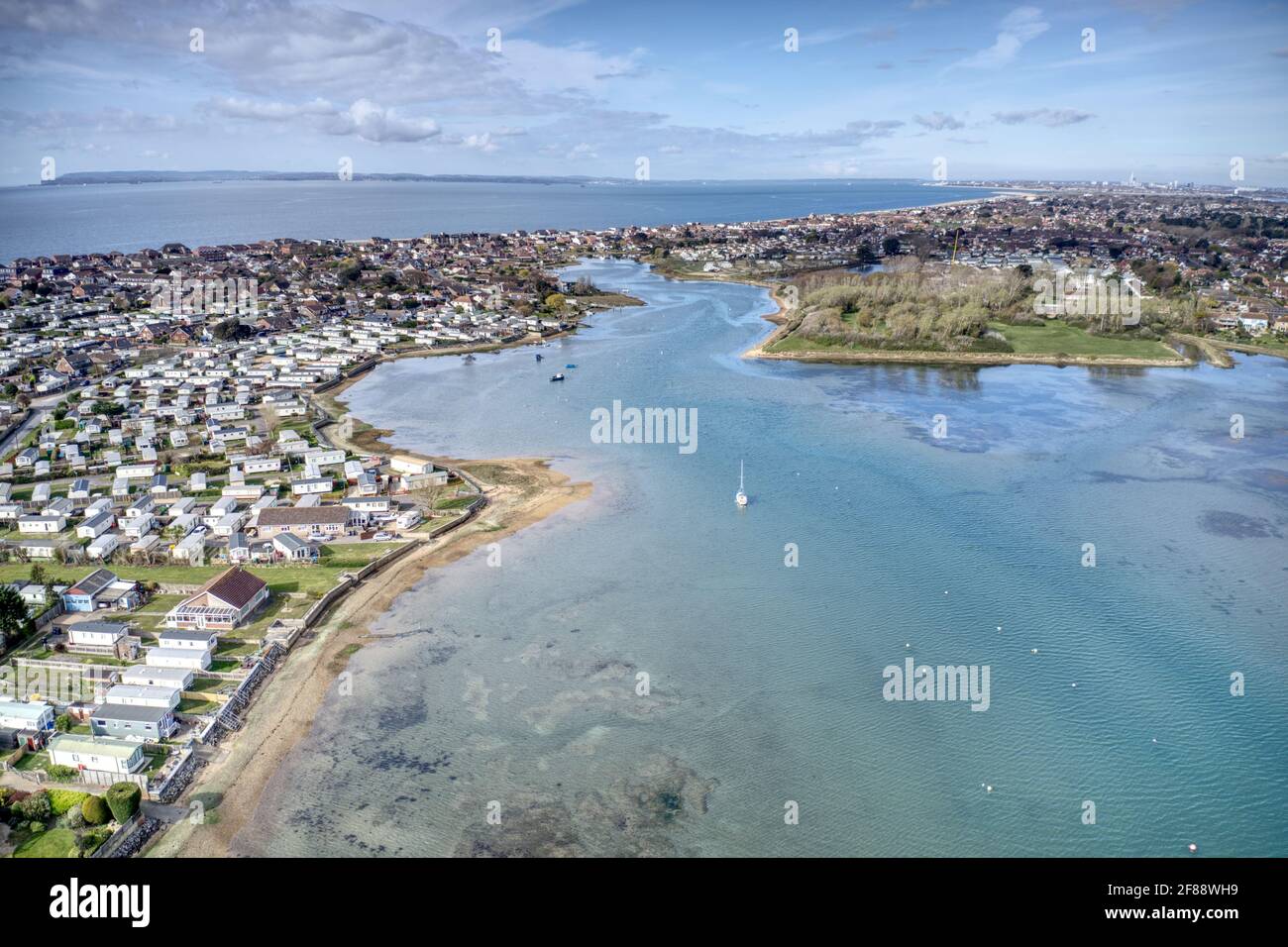 Vista aerea di Hayling Island di un bellissimo estuario che conduce al centro di South Hayling con parchi vacanze, con club di vela e campagna. Foto Stock