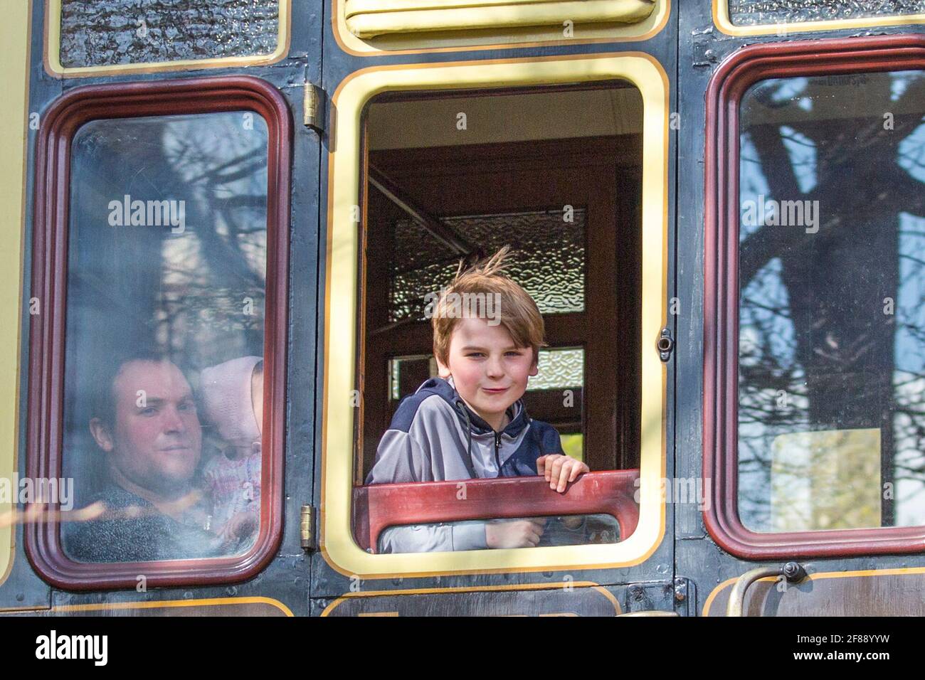 Bewdley, Regno Unito. 12 aprile 2021. La ferrovia della valle di Severn ti aspetta con tutta la sua energia, poiché questa ferrovia storica sempre popolare si riapre dopo l'allentamento delle restrizioni di blocco oggi. La famiglia catturata qui a bordo del servizio "Adventurer" sta tornando a casa a Bridgnorth dopo una favolosa giornata in ferrovia, godendosi il sole del pomeriggio. Credit: Lee Hudson/Alamy Live News Foto Stock
