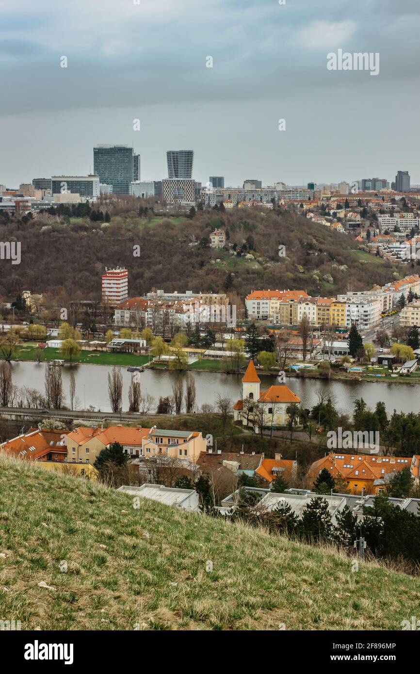 Vecchie case, piccola chiesa con tetto rosso, moderno grattacielo di vetro nel retro, Praga, ceco republic.Real estate residenziale concept.Czech architettura Foto Stock