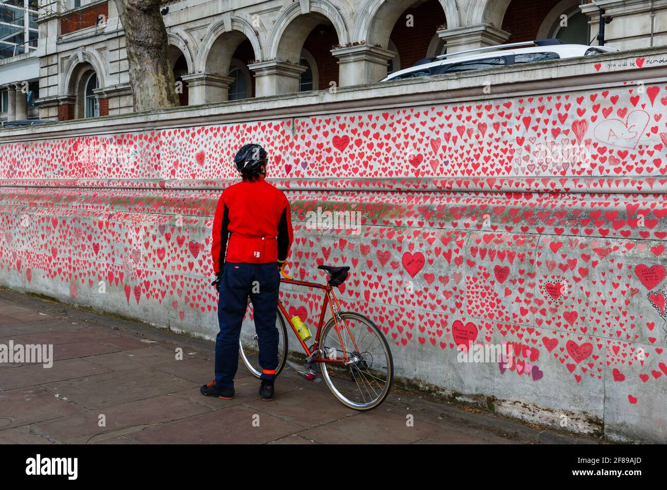 I passanti osservano i cuori rossi dipinti sul National Covid Memorial Wall come tributo alle vittime britanniche Di Corornavirus Foto Stock