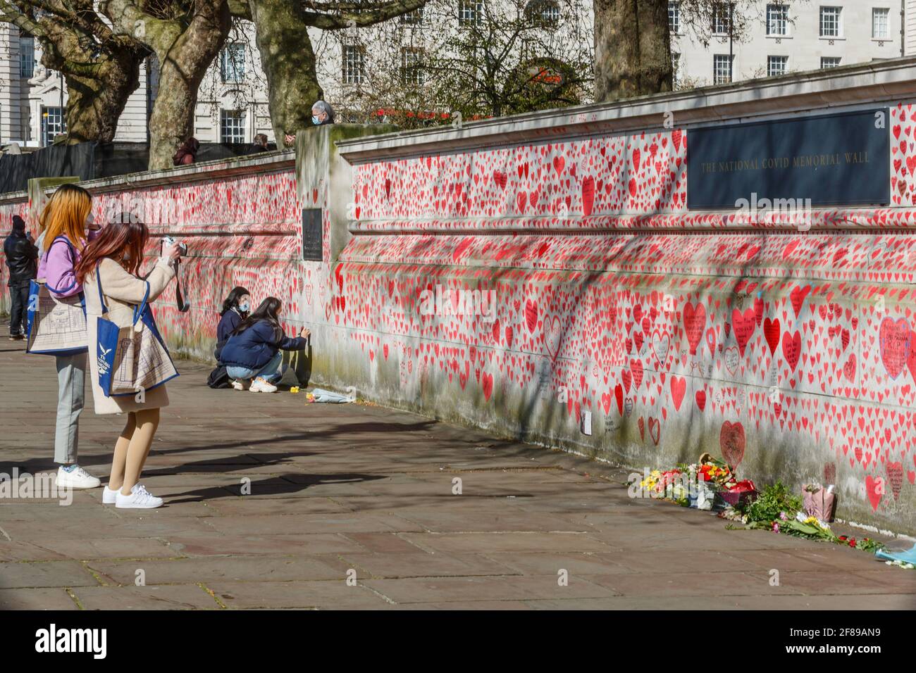 I passanti osservano i cuori rossi dipinti sul National Covid Memorial Wall come tributo alle vittime britanniche Di Corornavirus Foto Stock