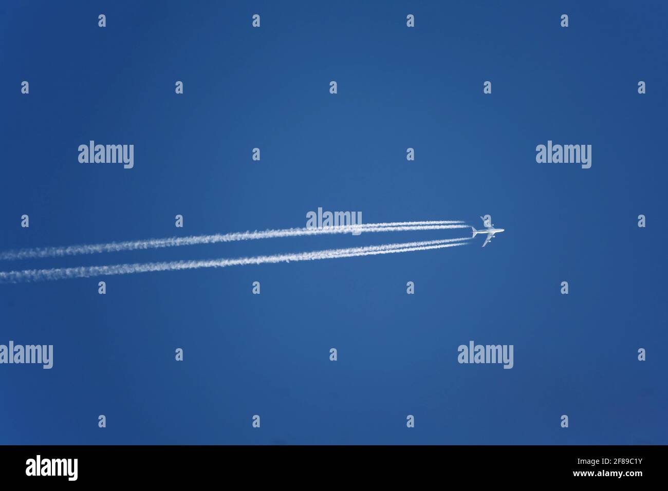 Aereo con contracche in cielo azzurro chiaro, altitudine di crociera. I getti lasciano i sentieri bianchi, o contrails, nei loro wakes per lo stesso motivo che potete qualche Foto Stock