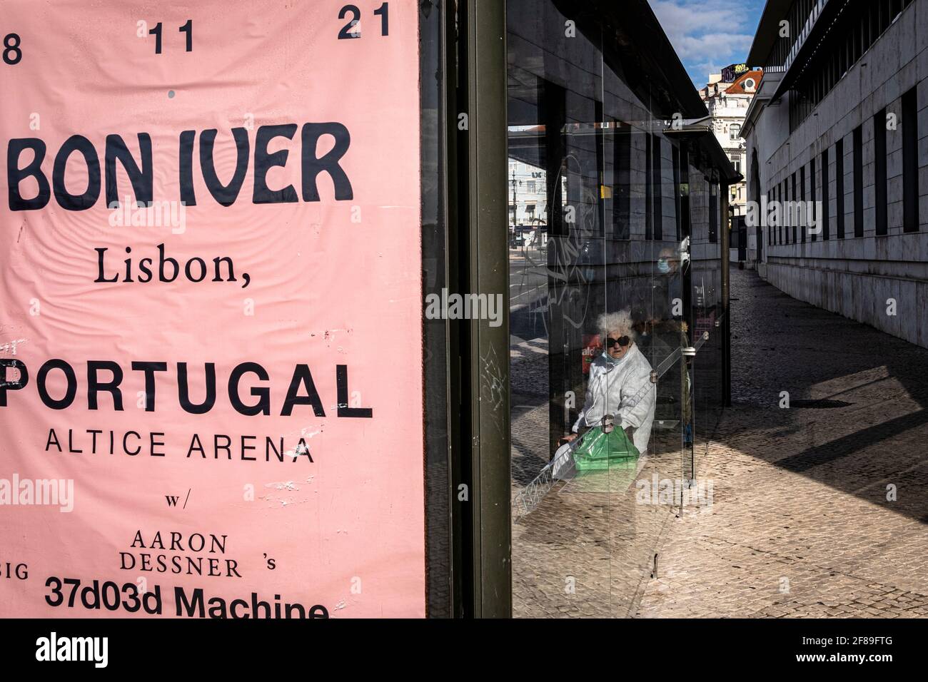 Lisbona, Portogallo - 30 Novembre 2020 : Donna guardando attraverso una fermata dell'autobus vetro Foto Stock