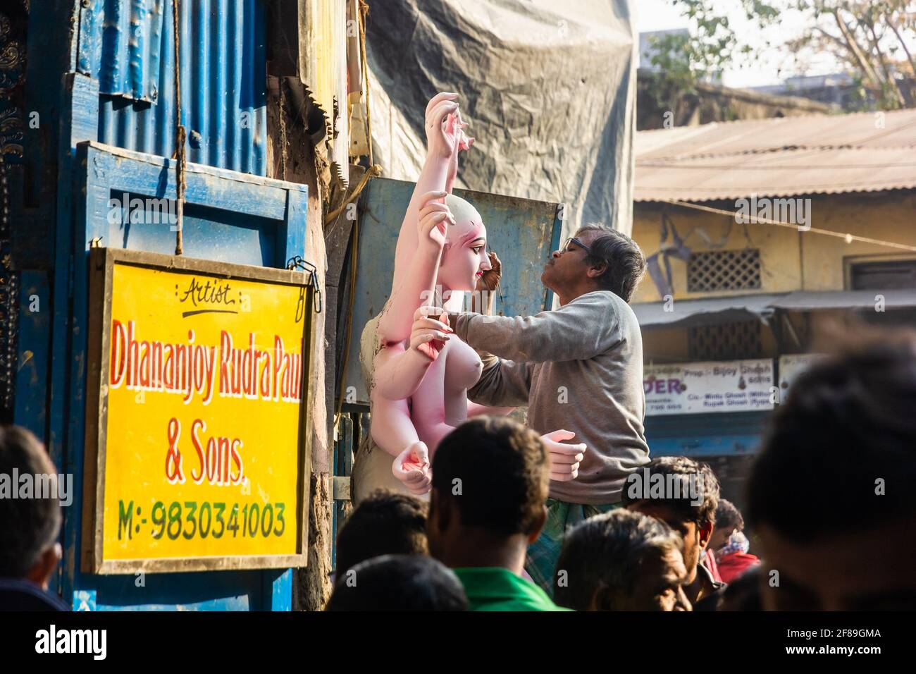 Kolkata, Bengala Occidentale, India - Gennaio 2018: Un uomo indiano che lavora su un idolo della Dea Indù Durga su una strada affollata a Kumartuli. Foto Stock