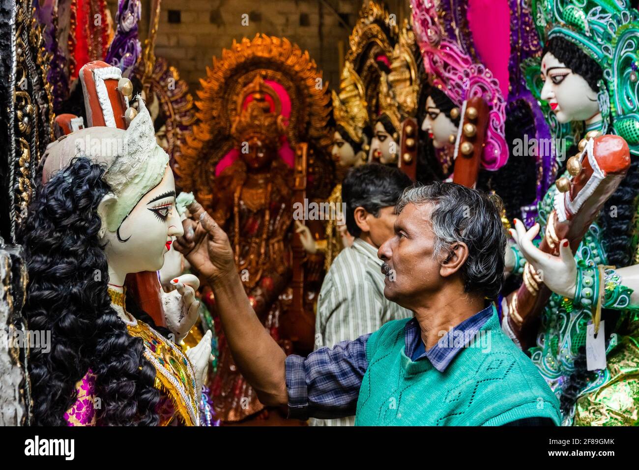 Kolkata, Bengala Occidentale, India - Gennaio 2018: Un uomo indiano lavora su un idolo di una Dea Indù per un festival nel suo laboratorio per le strade di Kumartu Foto Stock