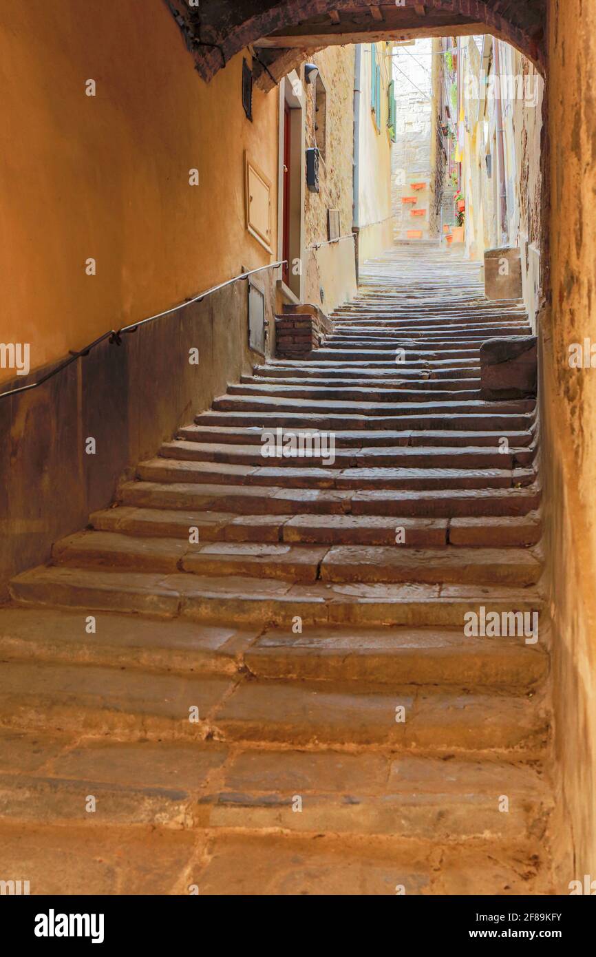 Cortona, Toscana, Italia. Vecchie scalinate coperte in pietra sotto un tunnel coperto ad arco in pietra. (Solo per uso editoriale) Foto Stock