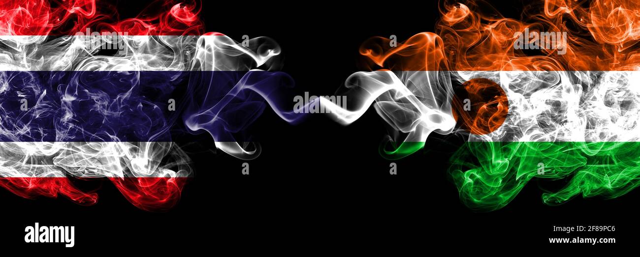 Thailandia, Tailandese vs Niger, nigerien fumoso mistico bandiere affiancate. Bandiere di fumo astratte spesse colorate in seta. Foto Stock