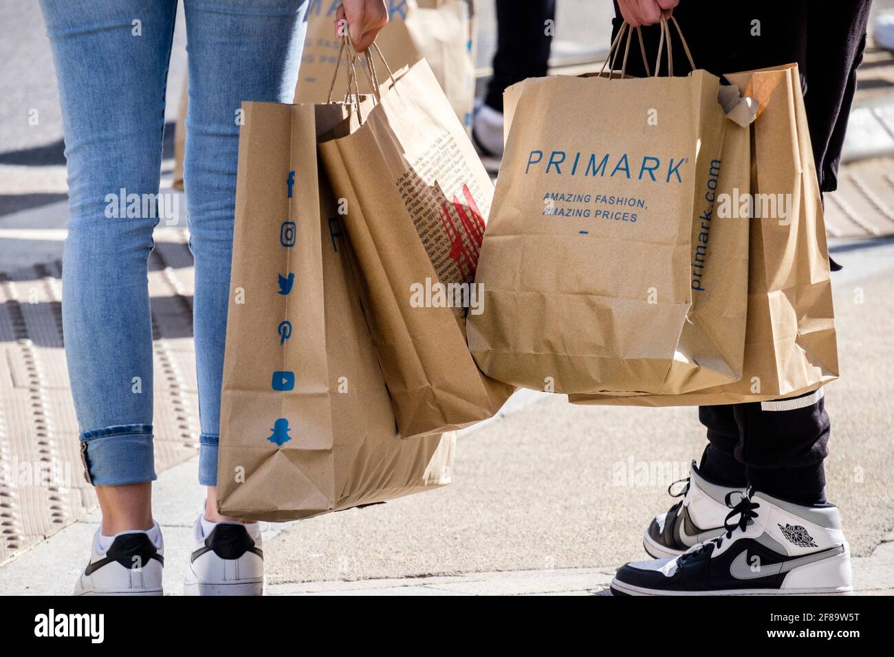 Clienti con borse per la spesa Primark, Londra, Regno Unito Foto Stock