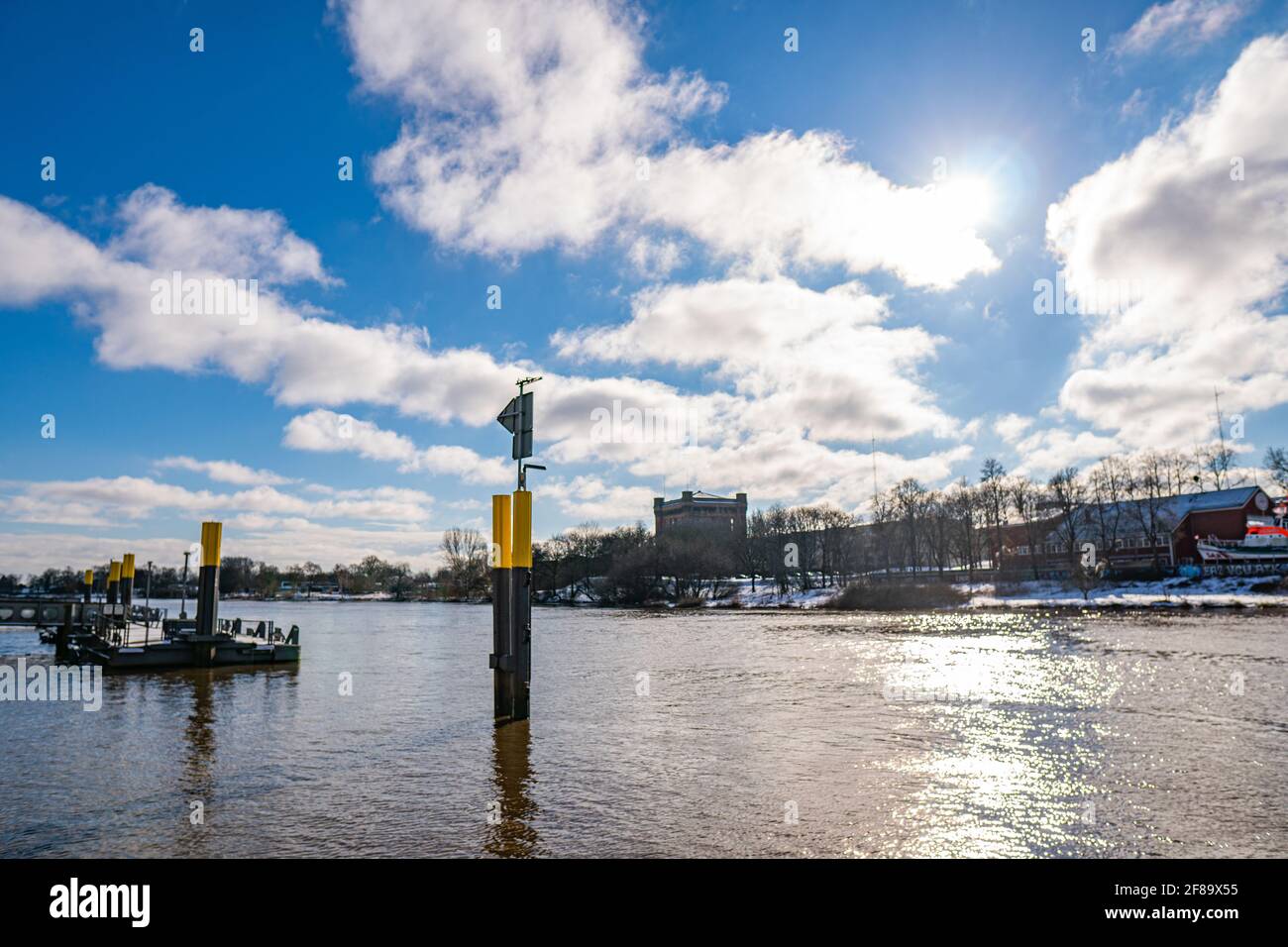 vista dalla diga con il molo torre d'acqua sullo sfondo al caldo sole e nuvoloso giorno d'inverno a brema Foto Stock