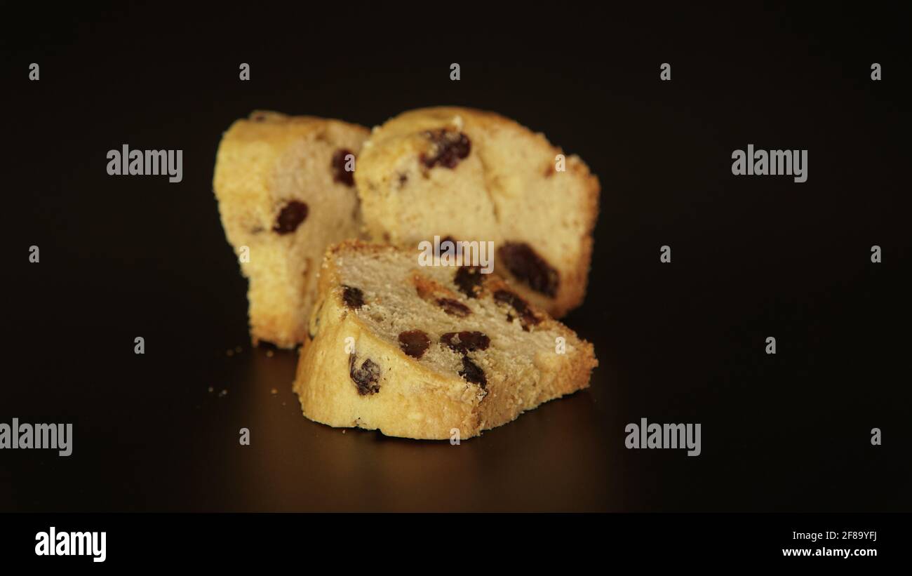 Pezzi di torta inglese con la frutta secca su sfondo nero. I tre pezzi dei dolci tipo muffin, chiamati anche torte di frutta. Il Foto Stock