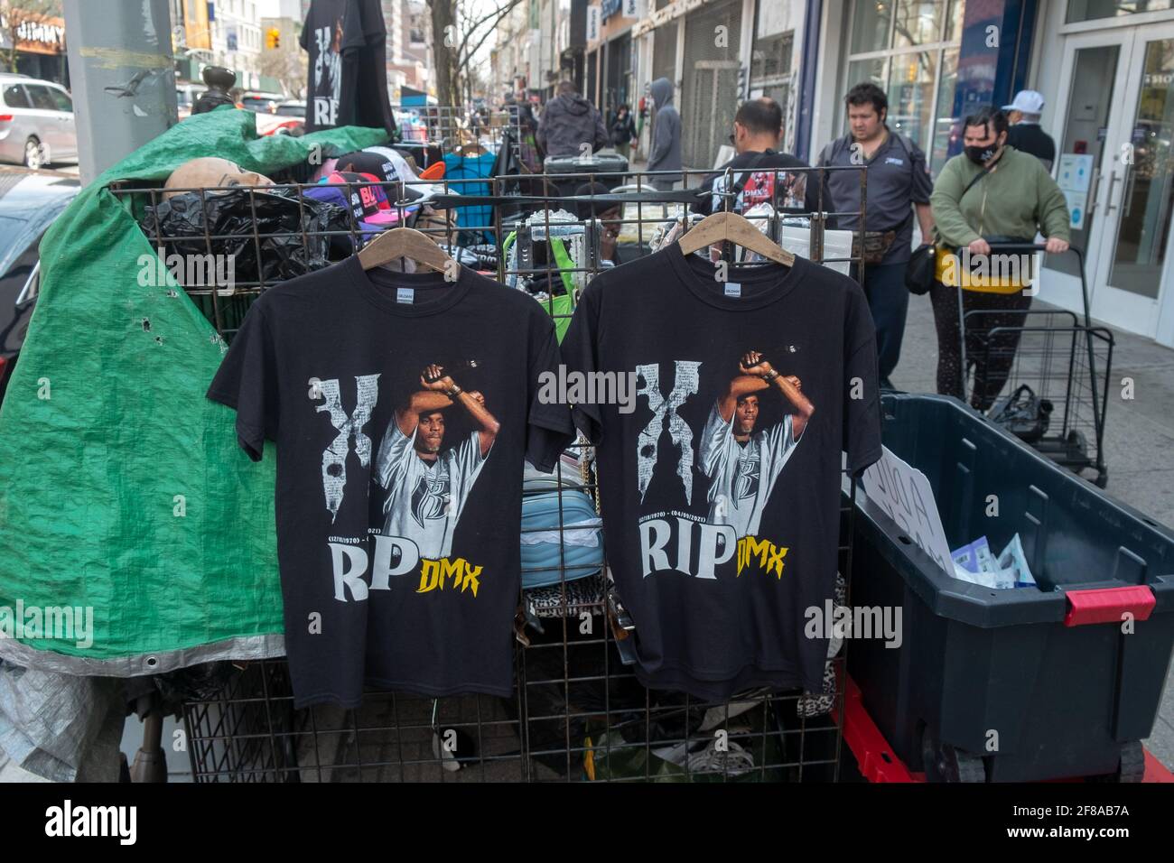 I venditori ambulanti vendono t-shirt con l'immagine del rapper americano DMX nel quartiere Harlem di New York. 10 Apr 2021 Foto Stock