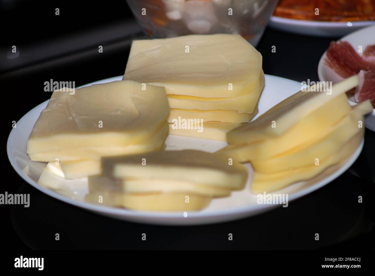 Piatto con fette di formaggio per raclette Foto Stock