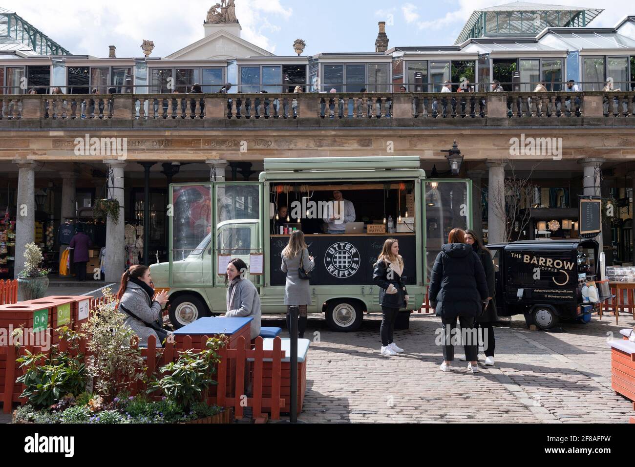 Londra, Gran Bretagna. 12 Aprile 2021. La gente cena all'aperto a Covent Garden a Londra, Gran Bretagna, 12 aprile 2021. In Inghilterra, tutti i negozi riaprono dal lunedì insieme ai parrucchieri, ai saloni di bellezza e ad altri servizi a contatto diretto. I ristoranti e i pub sono autorizzati a servire cibo e alcol ai clienti seduti all'aperto. Nel frattempo, palestre, terme, giardini zoologici, parchi a tema, le biblioteche e i centri comunitari possono aprirsi. Credit: Ray Tang/Xinhua/Alamy Live News Foto Stock