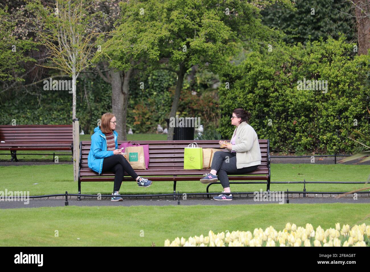 Dublino. 13 Apr 2021. La gente chiacchiera all'aperto a Dublino, Irlanda, 12 aprile 2021. Lunedì l'Irlanda ha iniziato ad attenuare alcune delle restrizioni COVID-19, come previsto. Le persone possono viaggiare liberamente all'interno della contea in cui vivono o entro 20 chilometri dalla loro casa, con incontri all'aperto consentiti per non più di due famiglie, l'istruzione in classe per tutti gli studenti della scuola primaria e secondaria ripresa, e tutti i progetti di costruzione residenziale riaperti. Credit: Xinhua/Alamy Live News Foto Stock