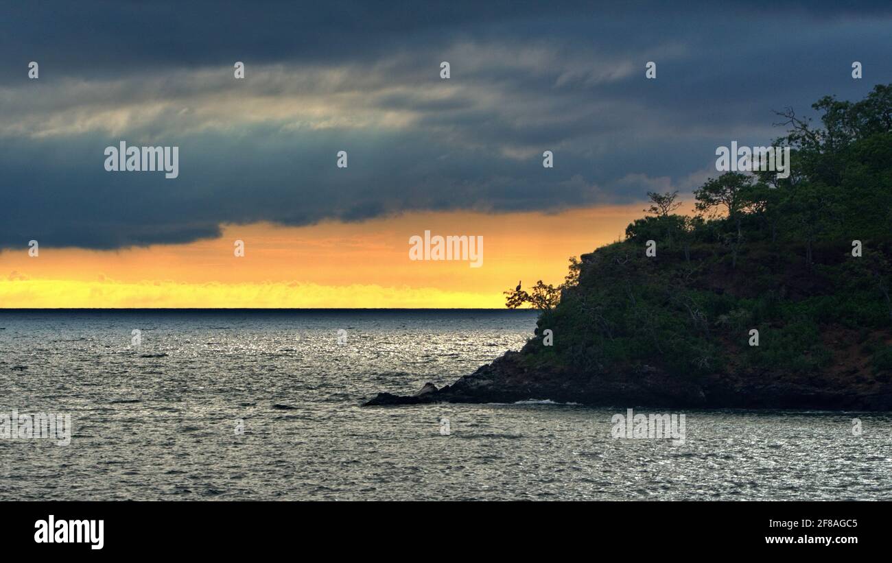 Tramonto dietro un isolotto roccioso vicino Elizabeth Bay, Isabela Island, Galapagos, Ecuador Foto Stock