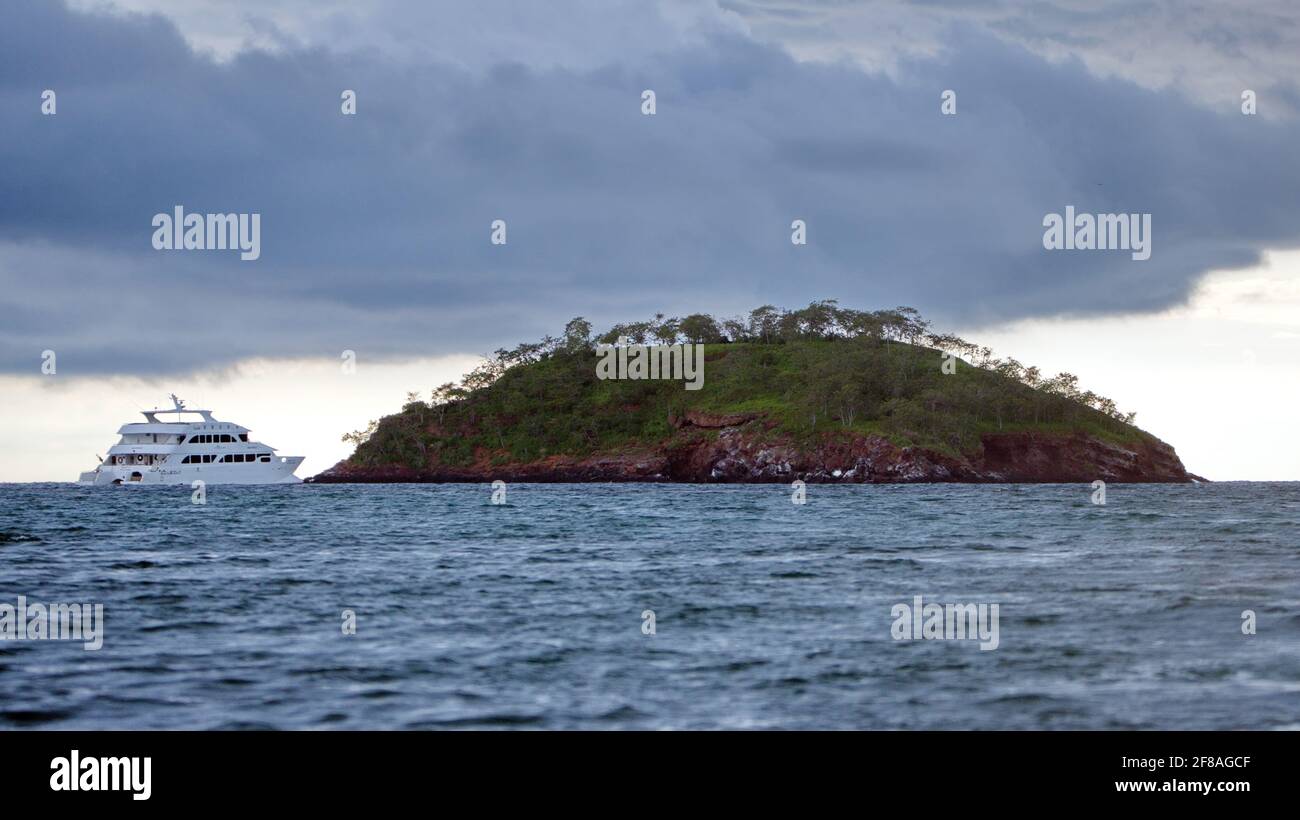 Galapagos crociera catamarano ormeggiato da un isolotto roccioso vicino Elizabeth Bay, Isabela Island, Galapagos, Ecuador Foto Stock