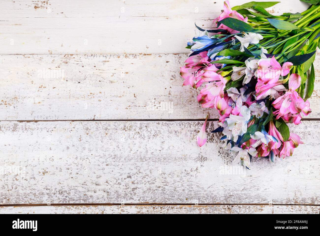 Bel bouquet di alstroemerie rosa e blu su sfondo ligneo. Foto Stock