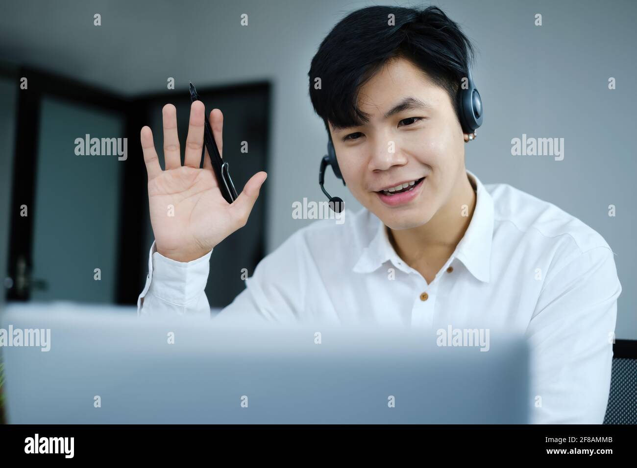 Ho una domanda. Uomo d'affari alzando le mani durante una conferenza online con il computer portatile. Evento imprenditoriale e imprenditoriale. Foto Stock