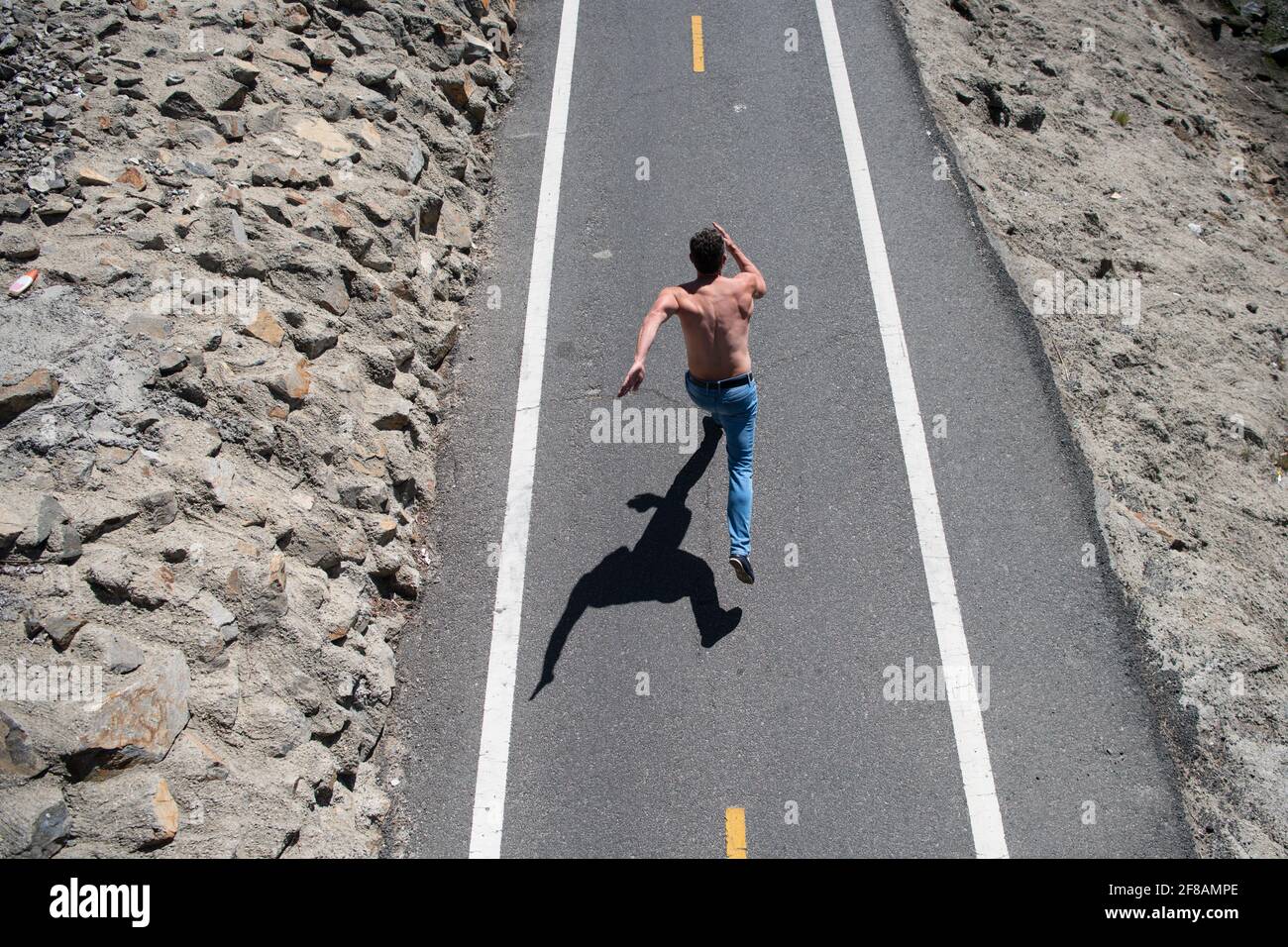 Vista posteriore del runner man che fa jogging su strada. Allenamento madel maschile con torso nudo su strada urbana. Foto Stock