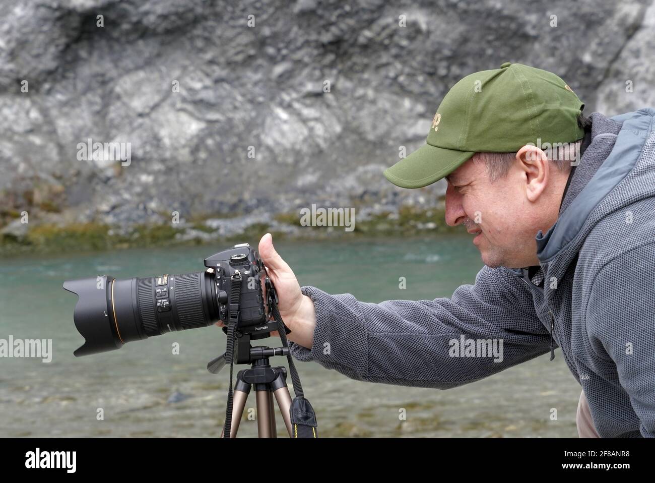Un fotografo con la sua macchina fotografica su uno stand in dettaglio per scattare foto di acque bianche del Reno nella Gola del Reno in Svizzera, chiamata Ruinaulta. Foto Stock