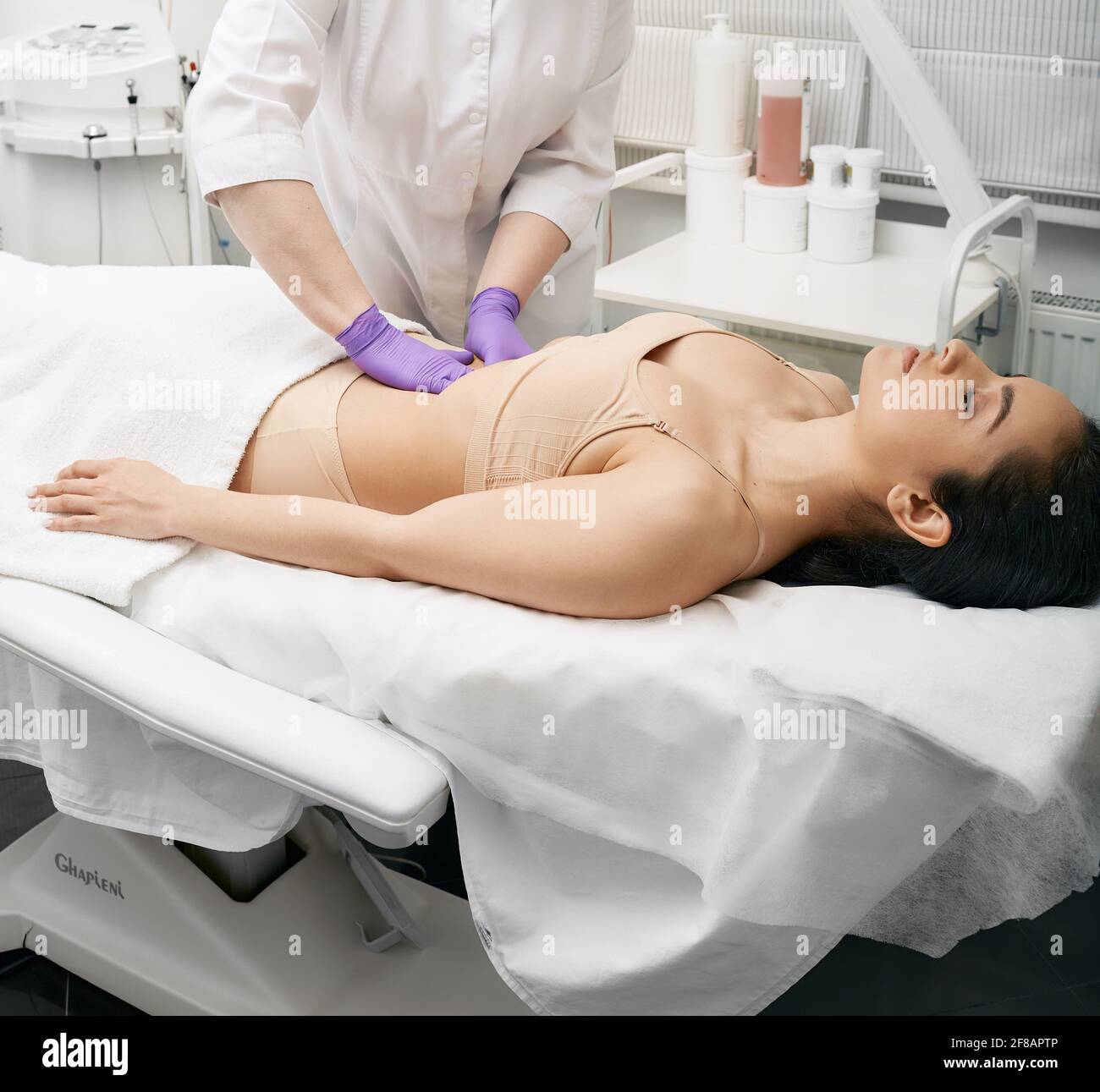 il medico palpa la pancia di una giovane donna in una clinica medica. Medico che fa un esame medico per il corpo femminile per la prevenzione delle malattie Foto Stock
