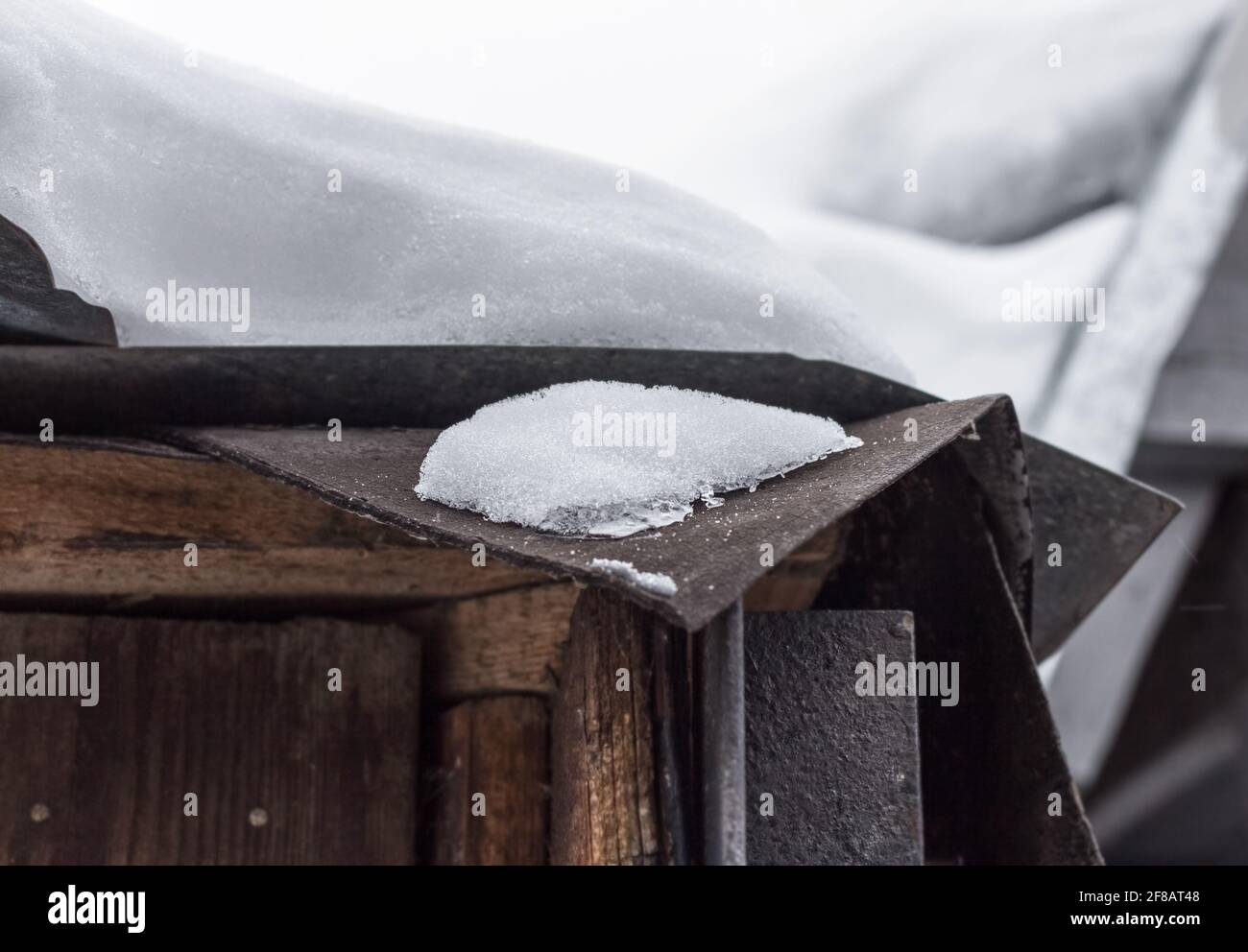 Vero e proprio strato spesso di neve sul vecchio tetto a nuvoloso giorno invernale Foto Stock