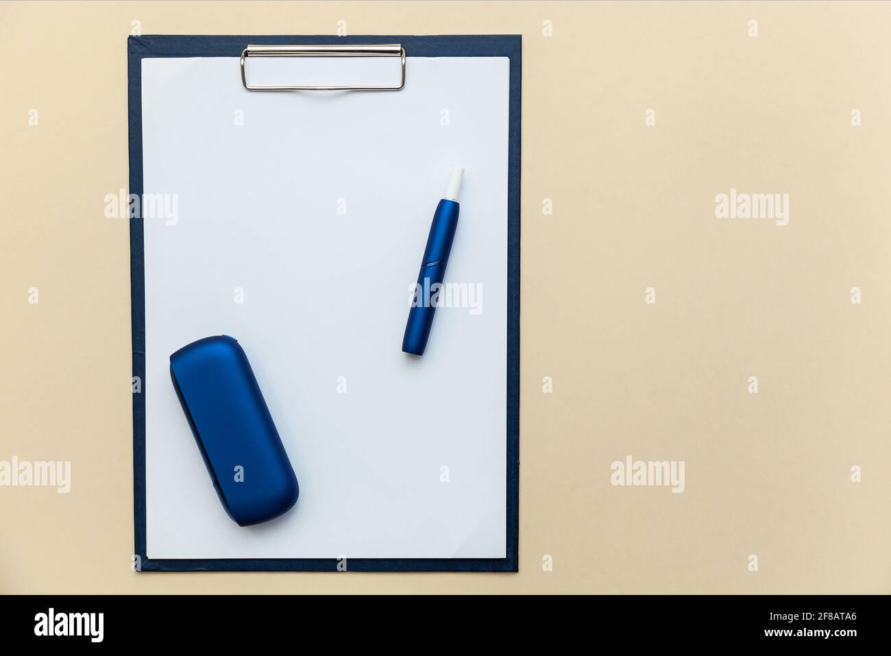 Sigaretta elettronica blu IQOS, piegatrice con clip per fogli di carta A4  su sfondo beige. Foto con luogo per il testo, il logo e il design. Concetto  o Foto stock - Alamy