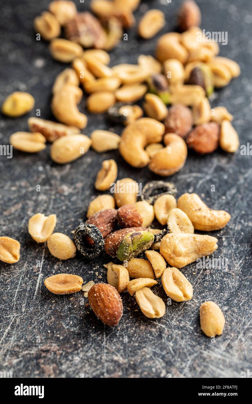 Mescolare le noci salate sul tavolo nero. Foto Stock