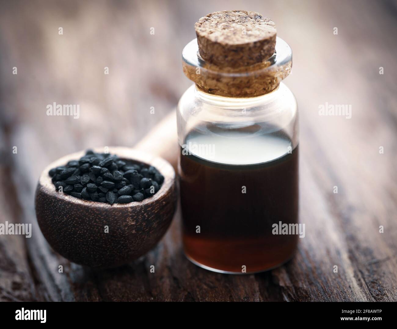 Nigella semi e olio essenziale in una bottiglia di vetro Foto Stock