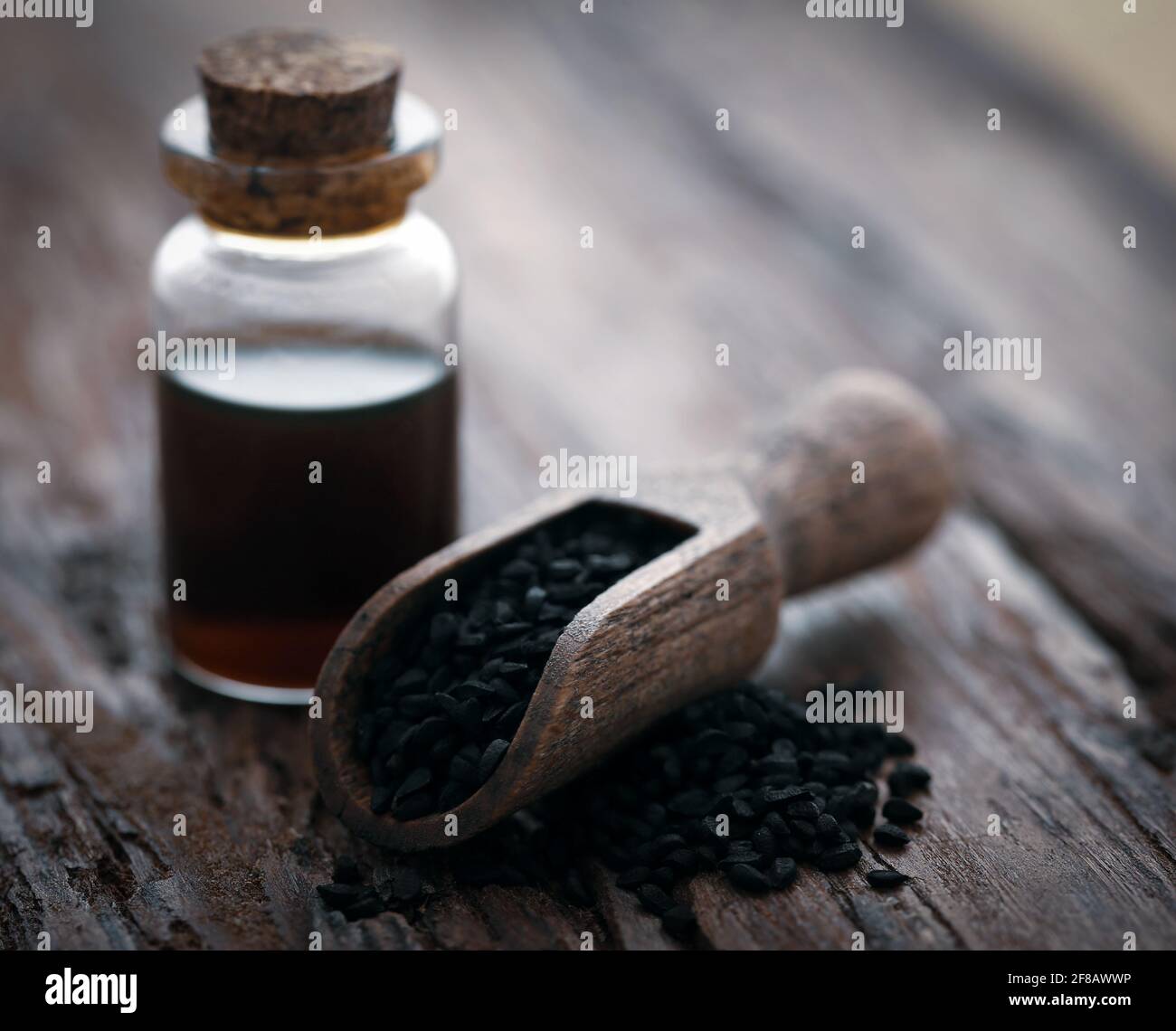 Nigella semi e olio essenziale in una bottiglia di vetro Foto Stock