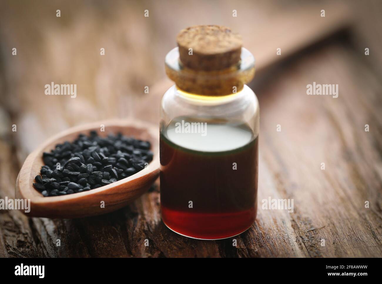 Nigella semi e olio essenziale in una bottiglia di vetro Foto Stock
