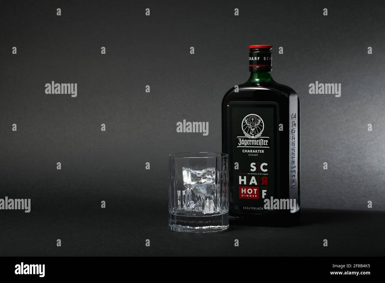 Praga, Repubblica Ceca - 12 Marzo ,2021: Bottiglia di Jagermeister e vetro con ghiaccio su sfondo nero. Jagermeister è un digestivo tedesco prodotto con 5 Foto Stock